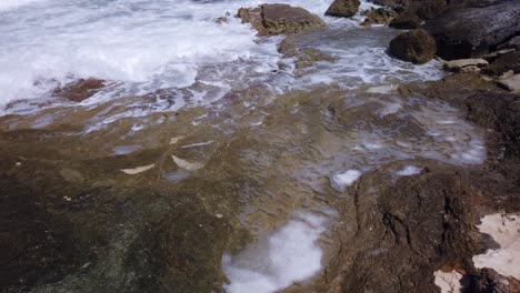 Waves-wash-onto-rocks-along-the-shore-of-a-Caribbean-island