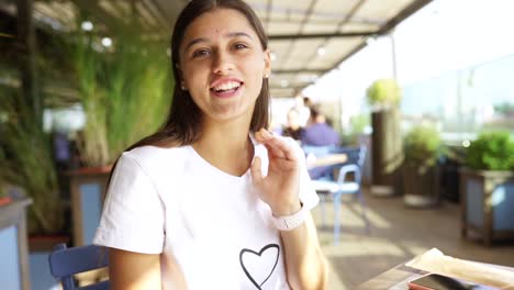 adolescente feliz en un café al aire libre