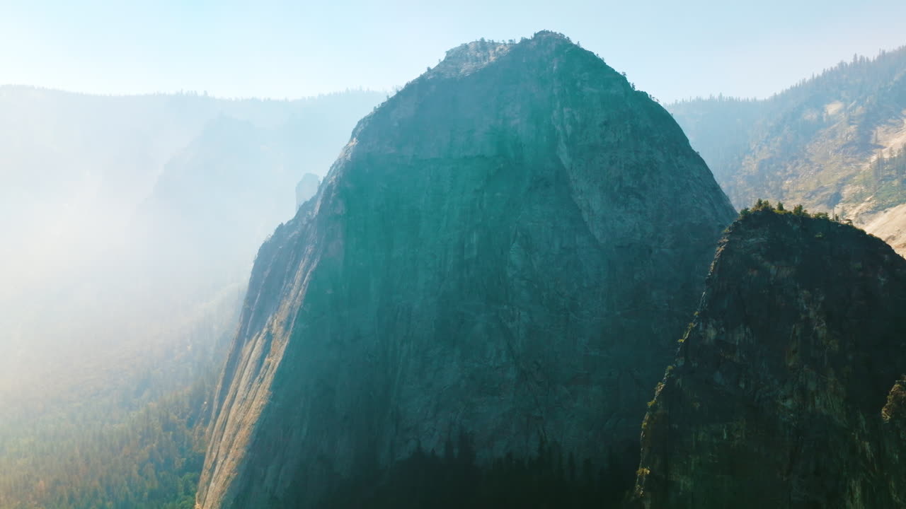 Bare cliff rock of Yosemite National Park, California, USA. Deep haze covering the horizon at backdrop.