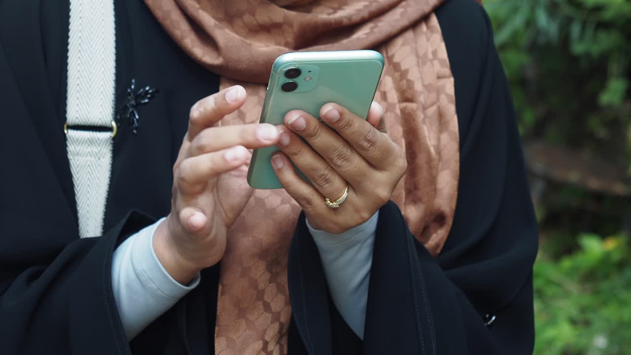 Close-up of a woman's hands using a smartphone outdoors