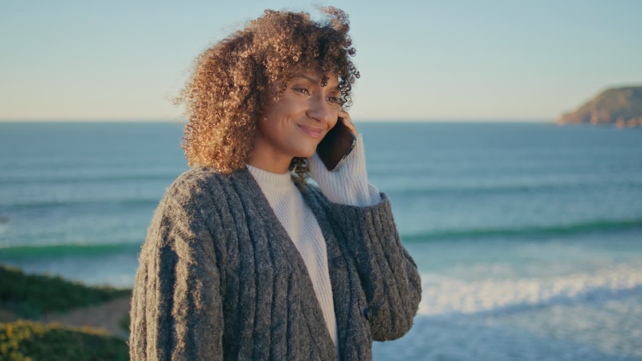 Tourist girl having call using cellphone at ocean closeup. Happy woman calling