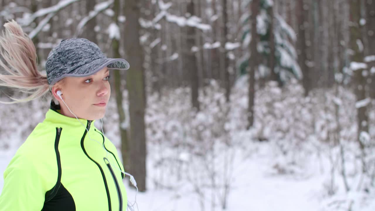 Young woman listening to music and running