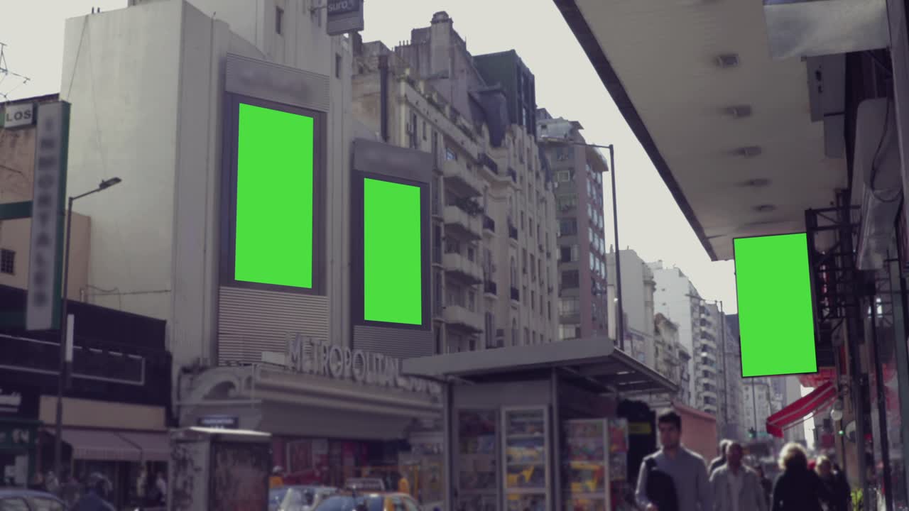 Bystreet med reklameskilte med grøn skærm og fodgængere