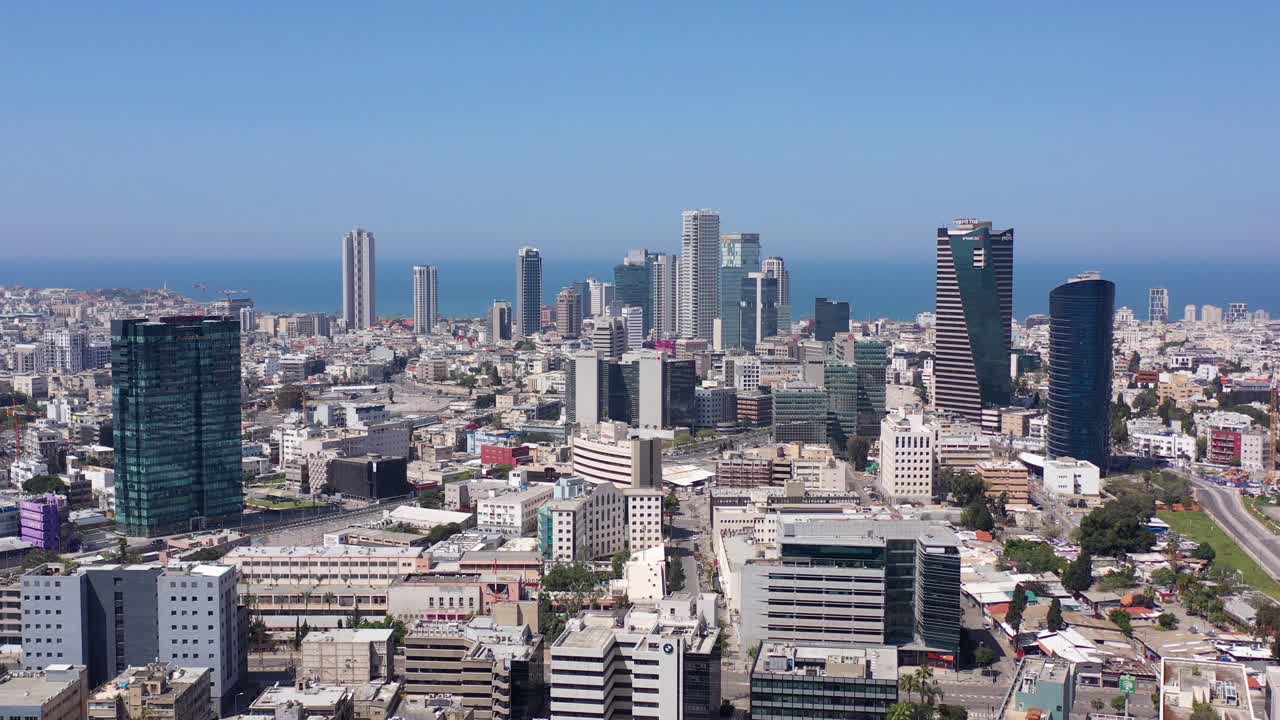 Aerial view of a modern city skyline with skyscrapers and the sea
