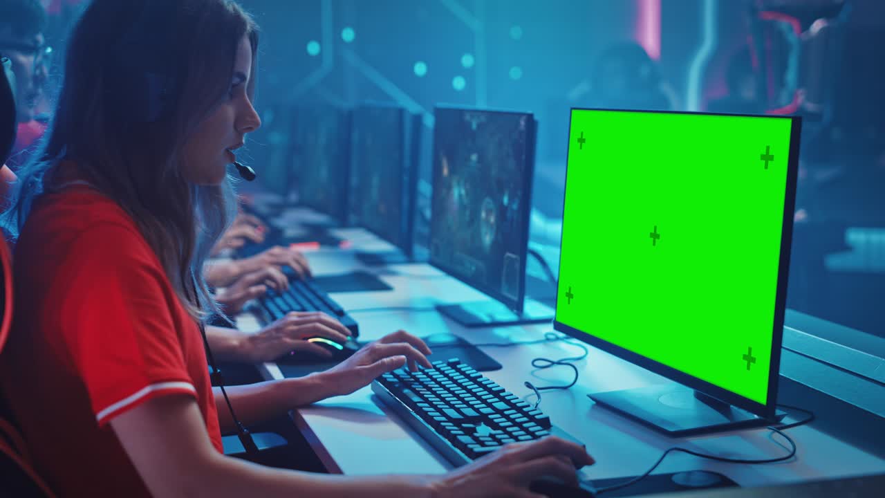 una chica profesional juega un juego de computadora con pantalla verde en un campeonato. un equipo diverso de jugadores profesionales juega en un simulacro de videojuego de estrategia rpg. estilo de juegos cibernéticos de neón.