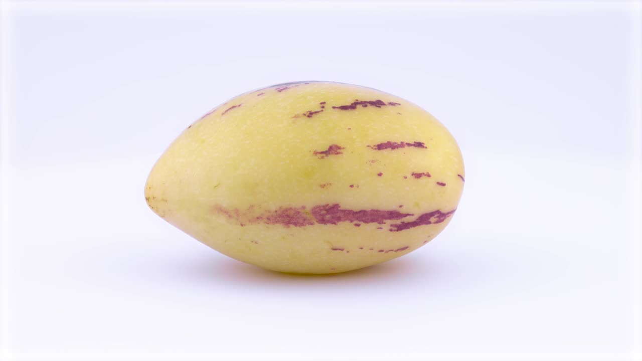una fruta de pepino amarilla madura está girando en la mesa giratoria aislada en el fondo blanco. primer plano. macro.