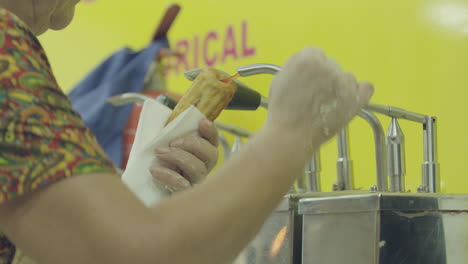 a woman stuffing farturas in deep oil at portugal summer village festivals