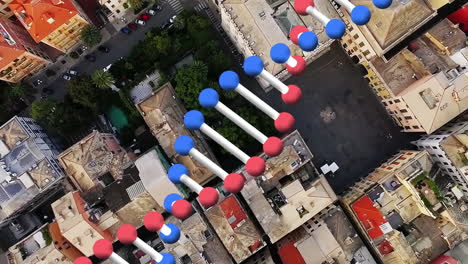 animation of rotating dna strand moving over aerial view of modern cityscape