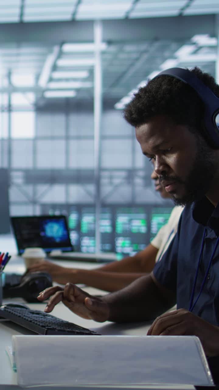 Vertical video Worker reading paperwork in data center, using analytics