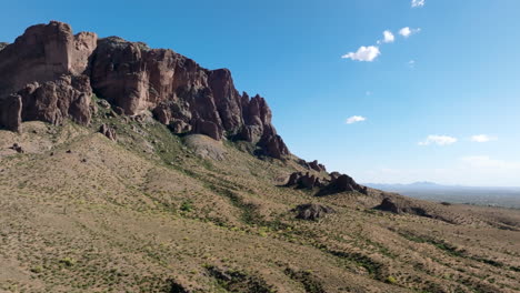 Orbit-establish-of-Superstition-Mountains-on-sunny-blue-sky-day-showcasing-sheer-rock-ledges