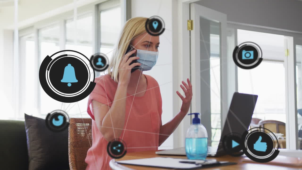 анимация цифровых икон над кавказской женщиной в маске для лица с помощью смартфона дома