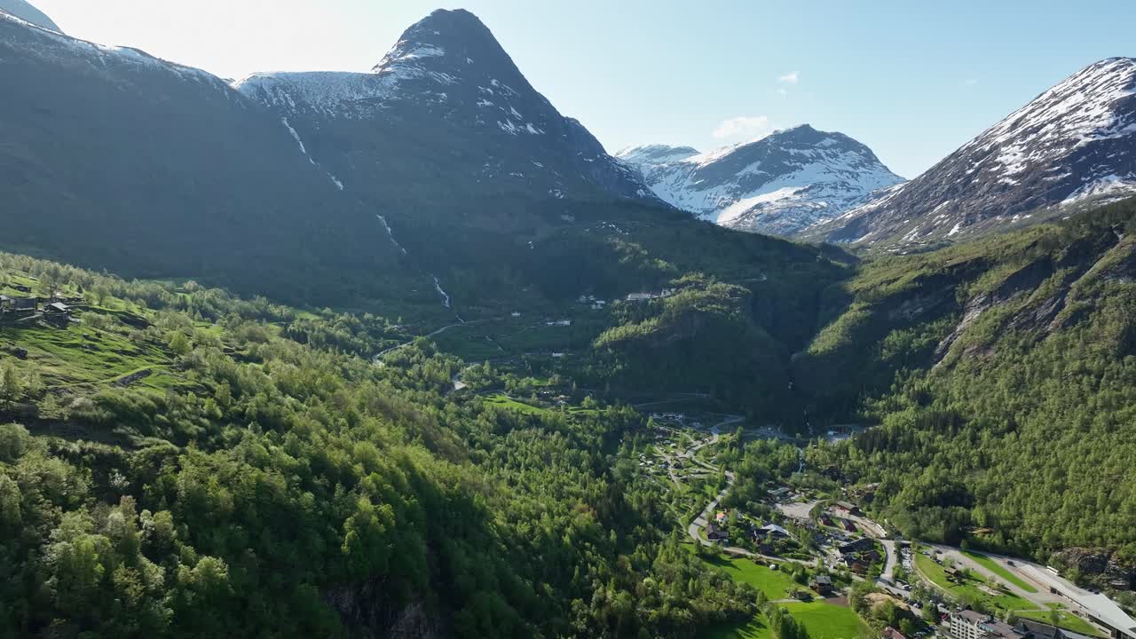 impresionante geiranger noruega - exuberante verano aéreo hacia el punto de vista de flydalsjuvet y el camino que va al cruce de la montaña - la unión del hotel apenas visible en el cuadro inferior y el fiordo detrás de la cámara