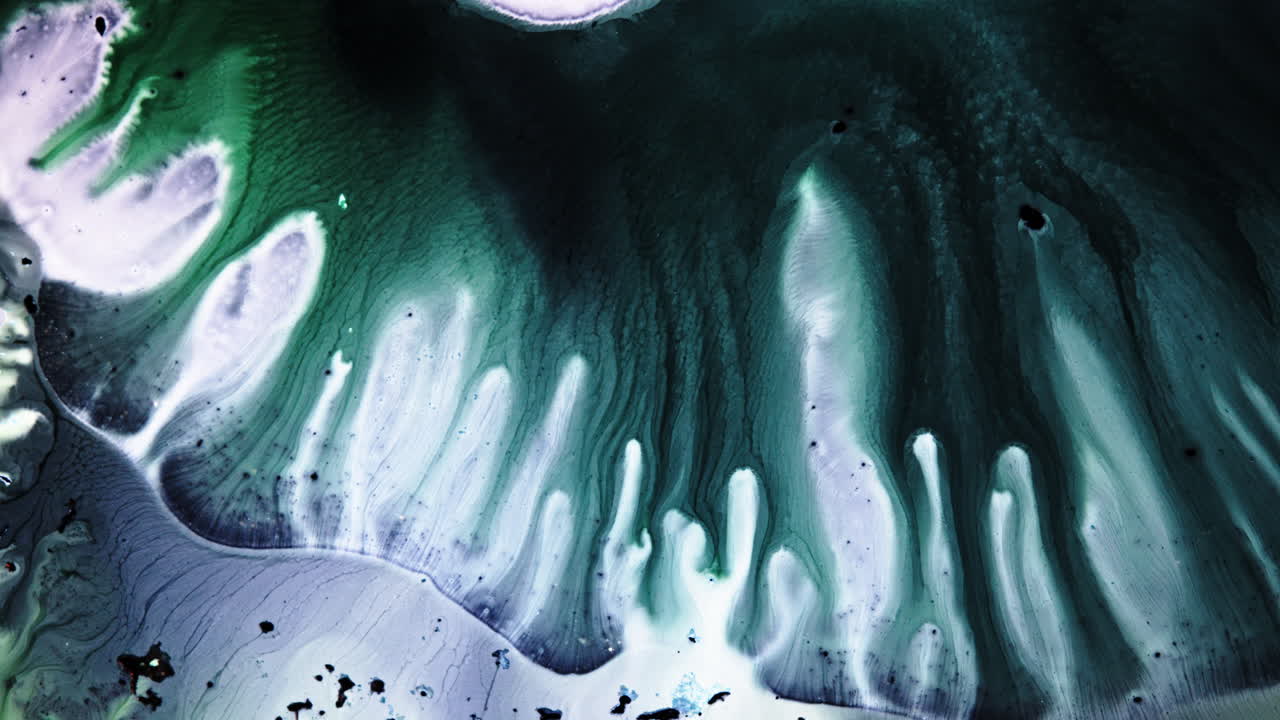 Tourbillon d'encre verte et blanche en vue macro, créant des motifs abstraits fluides.