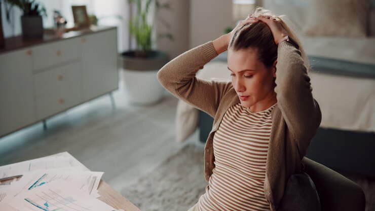 Pregnant woman working from home, feeling stressed