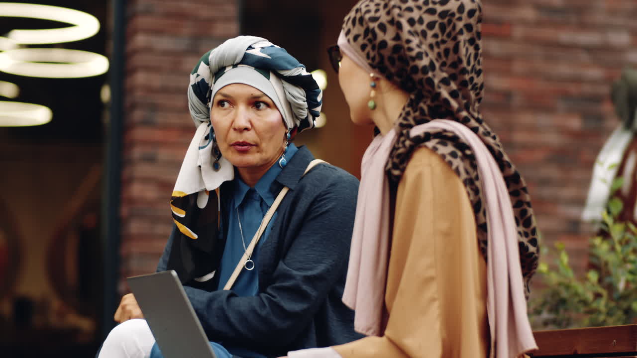 사무실 건물 밖 에서 이야기 하는 여성 동료 들