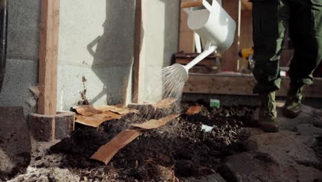 Watering-Garden-Plot-With-Pieces-Of-Cardboard-For-Mulching