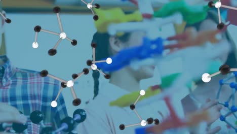 Molecular-structure-icons-against-group-of-students-touching-molecular-structure-model-at-laboratory