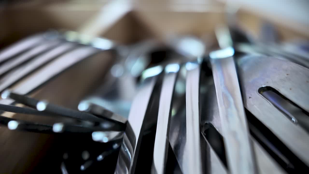 Close-up of metal forks organized in a wooden kitchen cutlery drawer