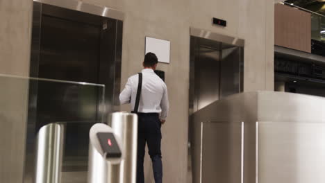businessman with bag waiting in front of elevator in office building