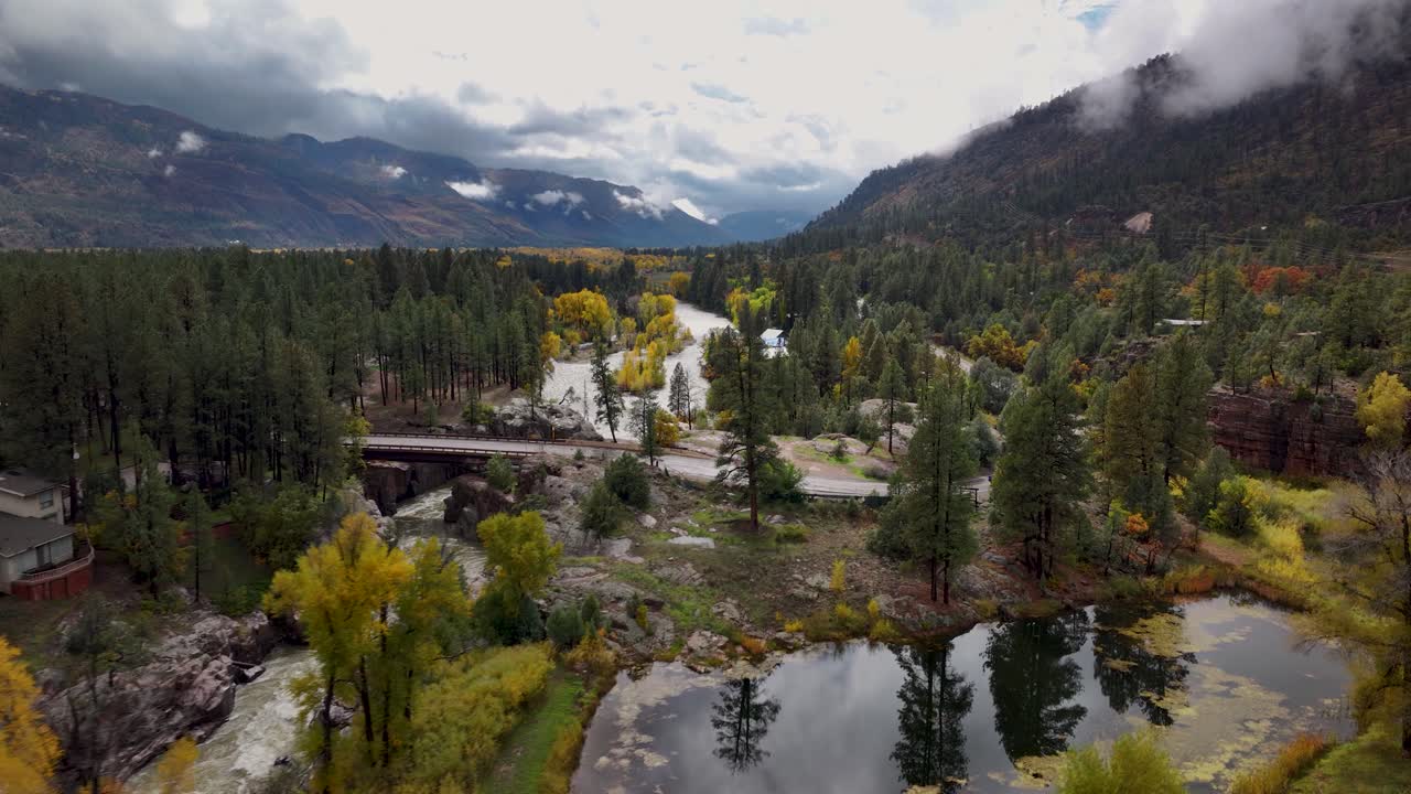 Ripresa aerea con drone che avanza sopra la linea degli alberi e lungo il fiume Animas, in Colorado, mostrando il vivace fogliame autunnale e il tortuoso percorso del fiume attraverso il colorato paesaggio autunnale