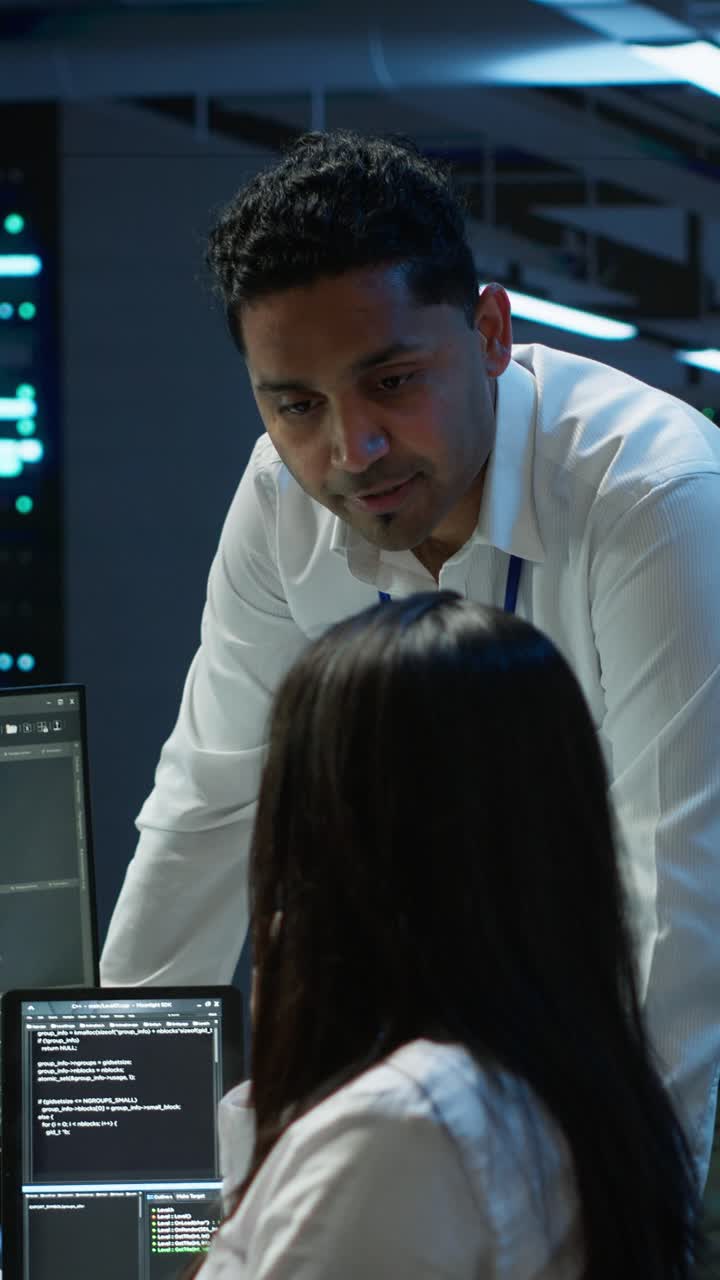 IT Professionals Discussing Code on Computer Screen in Data Center