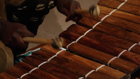 hands playing a wooden marimba or traditional percussion instrument