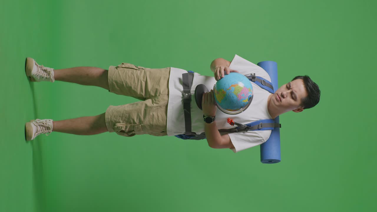 hombre con mochila y globo frente a la pantalla verde