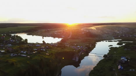 sunrise over a rural village with river and lake