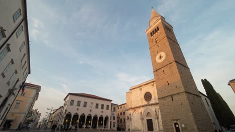 town square with a church tower in italy