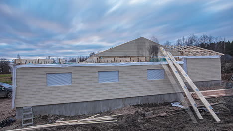 timelapse of workers on roof building wooden house under cloudy sky