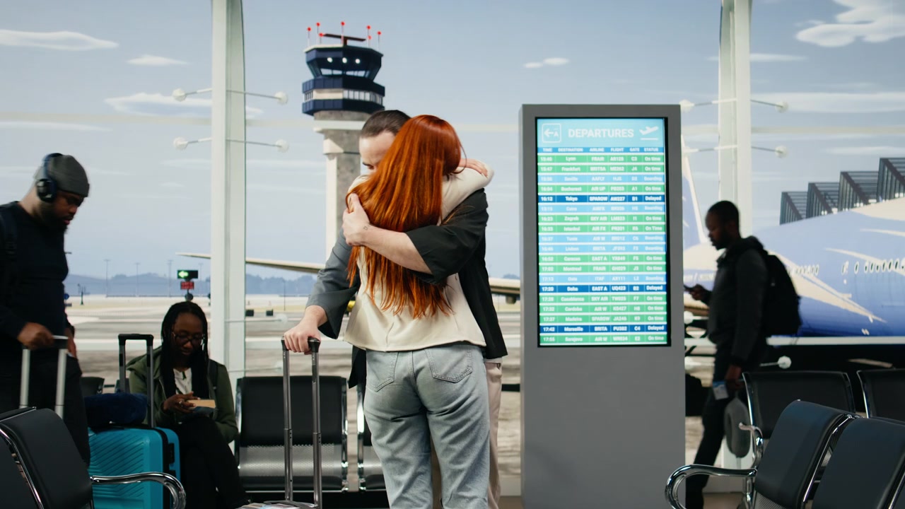 Mujer abrazando a su novio al despedirse en el aeropuerto