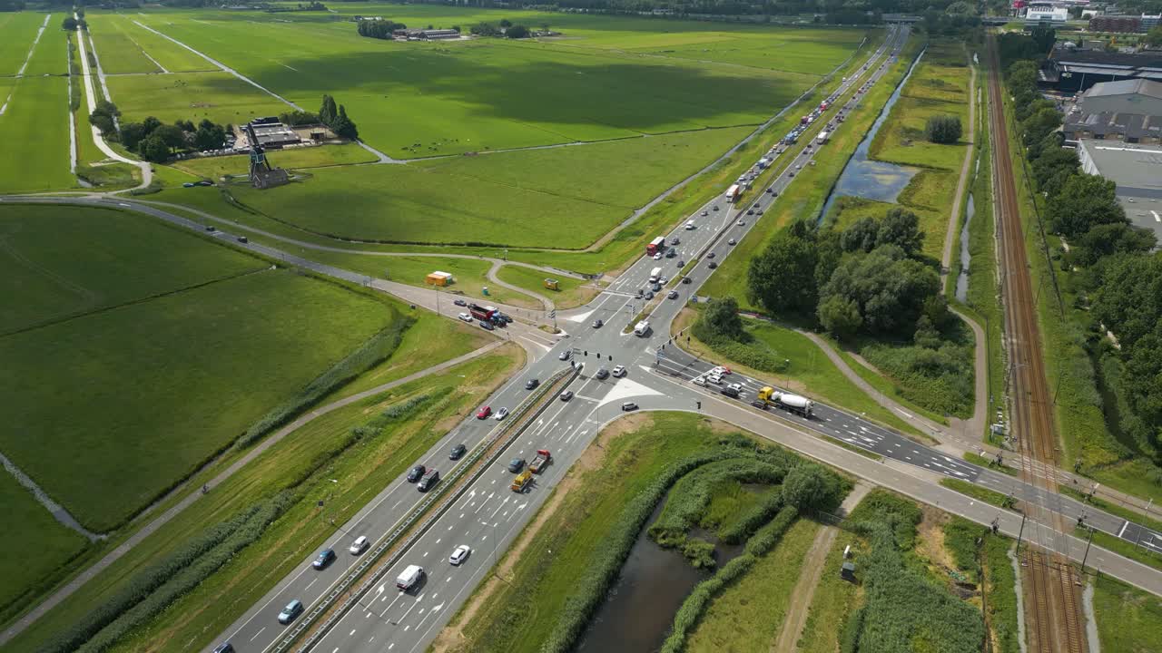 Drone clip showing a major highway crossing with cars, bike paths, and surrounding green fields
