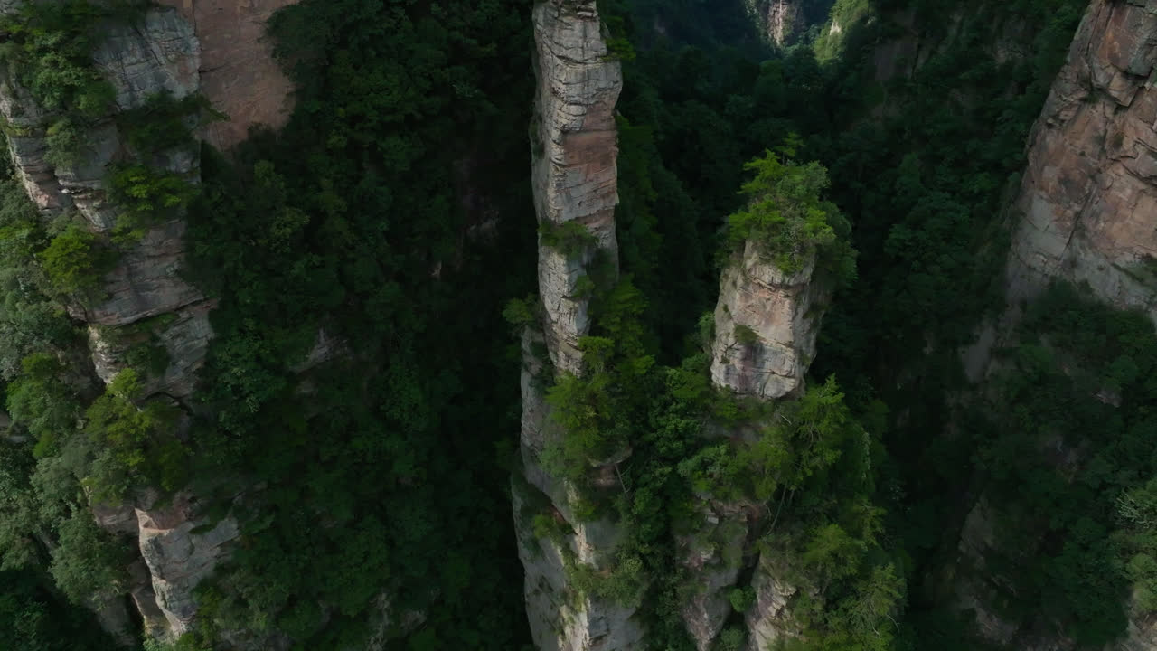 Aerial view tilting in front of towering sandstone spires in Zhangjiajie, China