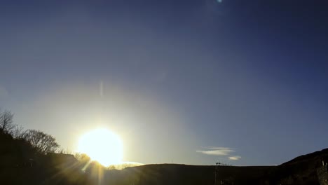 timelapsed sunset with a silhouetted hillside framing the bottom of shot.