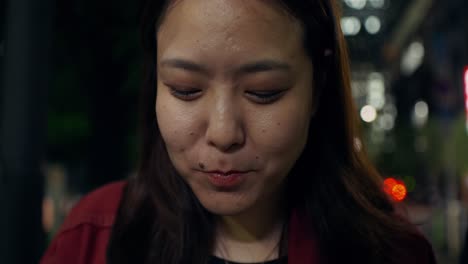 woman eating noodles outside at night