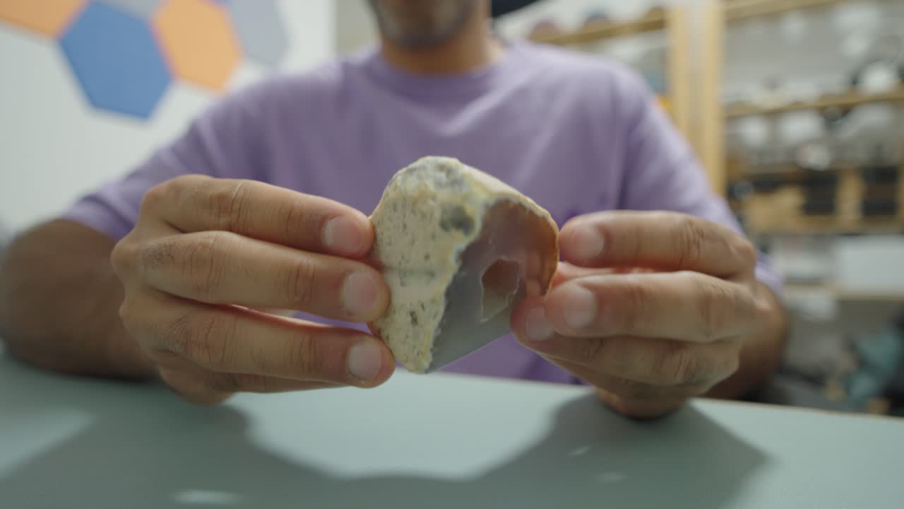 Close up of hands presenting a geode, emphasizing textures, natural formation and a calm moment of discovery at home