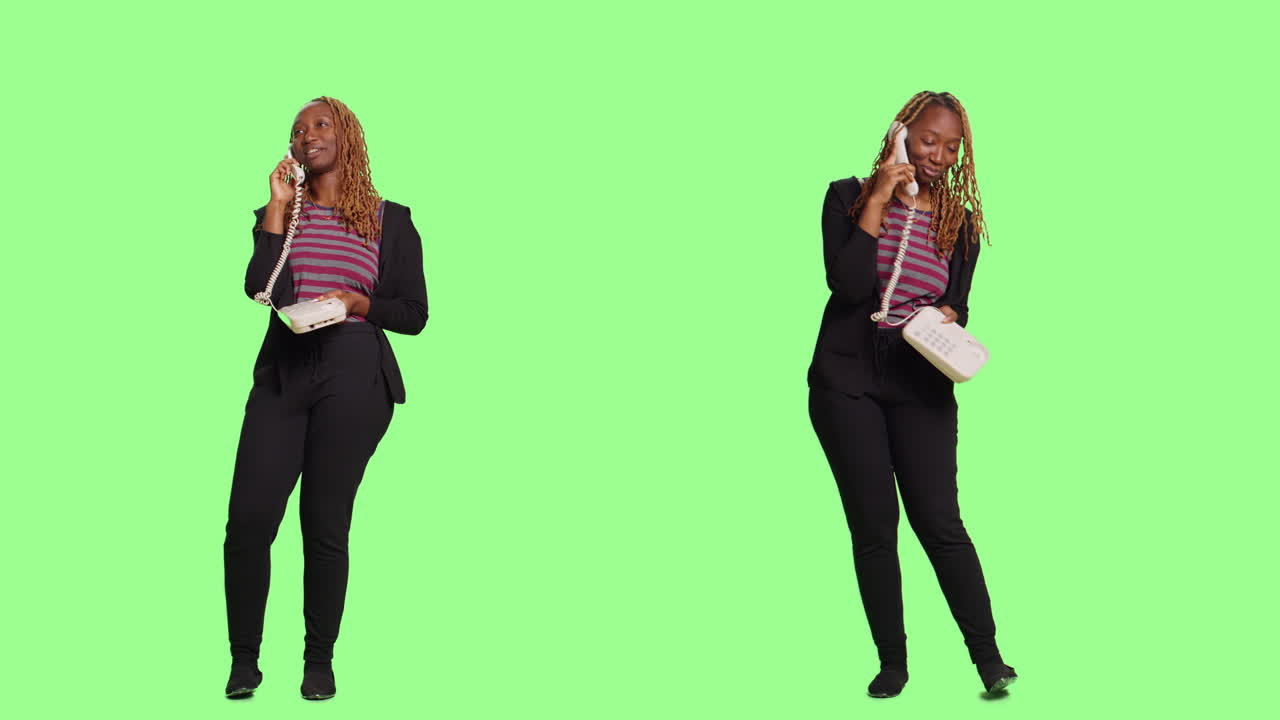 Studio shot of professional woman talking on landline telephone in suit