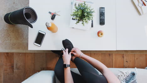 Overhead-Shot-Looking-Down-On-Woman-At-Home-Getting-Ready-To-Go-To-Fitness-Class