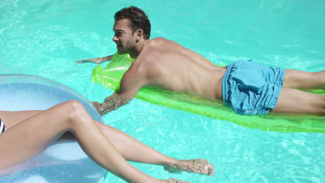couple relaxing together in swimming pool