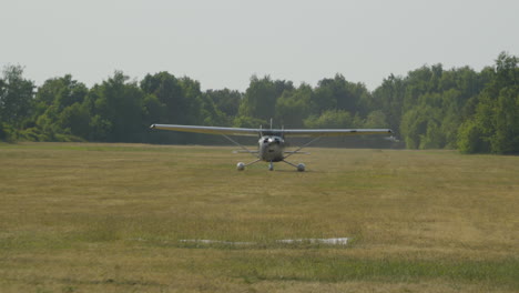 a small plane with a center propeller landed in a clearing