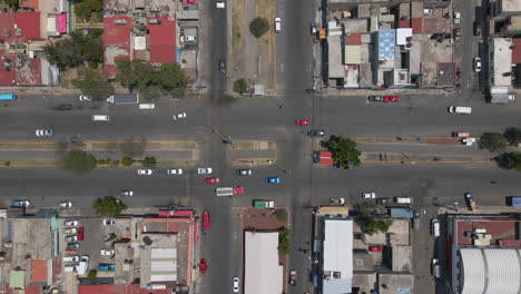 Aerial-top-down-static-view-vehicles-at-junction,-cross-road-in-ecatepec-neighborhood,-Mexico-city-north-suburbs-background