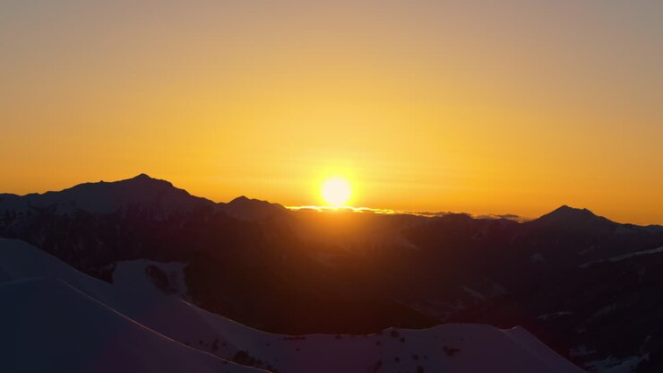 Filmato drone cinematografico 4K di Gudauri nelle montagne del Caucaso all'alba, che mostra splendidi colori dell'ora d'oro che illuminano cime alpine innevate. Gudauri_112
