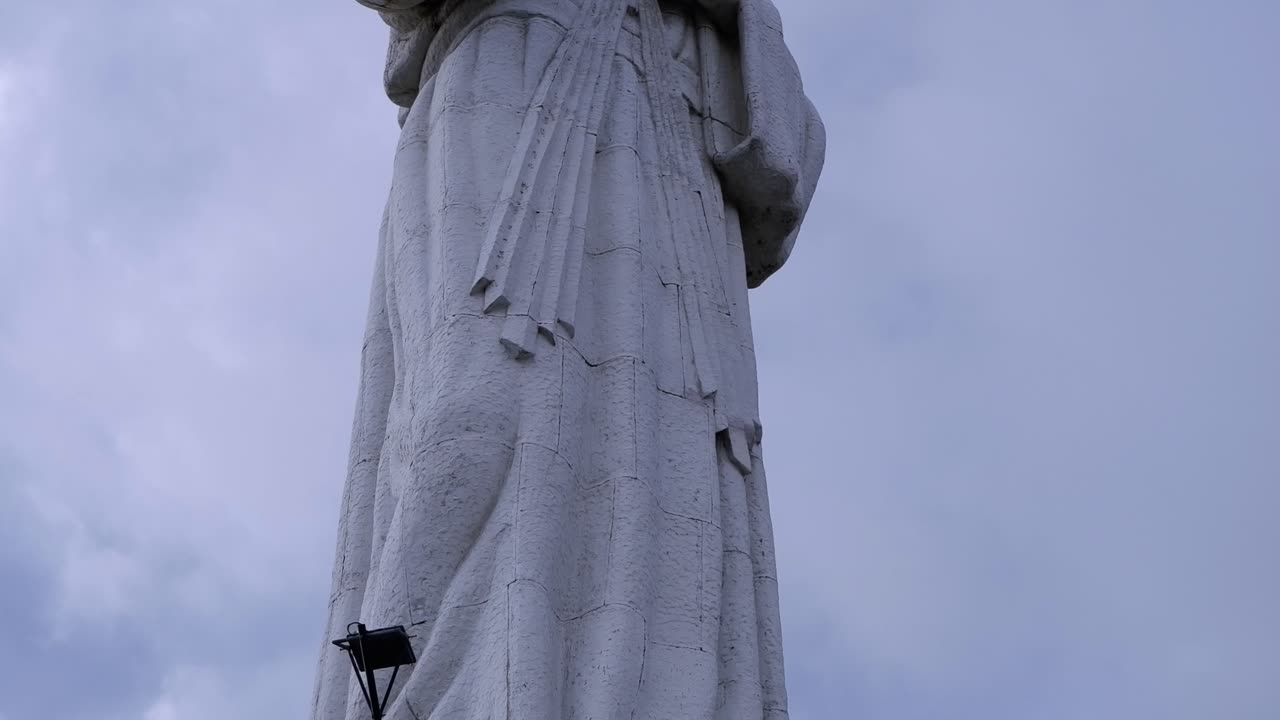 Gesù confido in te, messaggio sotto la scultura di Gesù Cristo su sfondo di cielo blu
