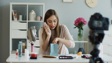 young fashion blogger recording video while talking about makeup and cosmetics to her followers