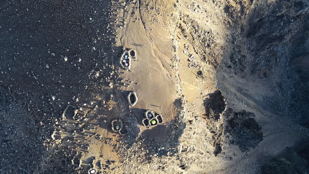 съемка с беспилотника сверху вниз палатки в кругу скал на вершине питон-де-нейж на острове воссоединения