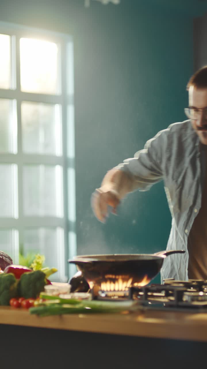 Man cooking a stir-fry in a kitchen with flambe