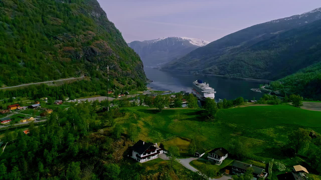un dron aéreo se disparó hacia adelante sobre la hermosa ciudad de aurlandsfjord rodeada por una cordillera en flam, noruega durante el día