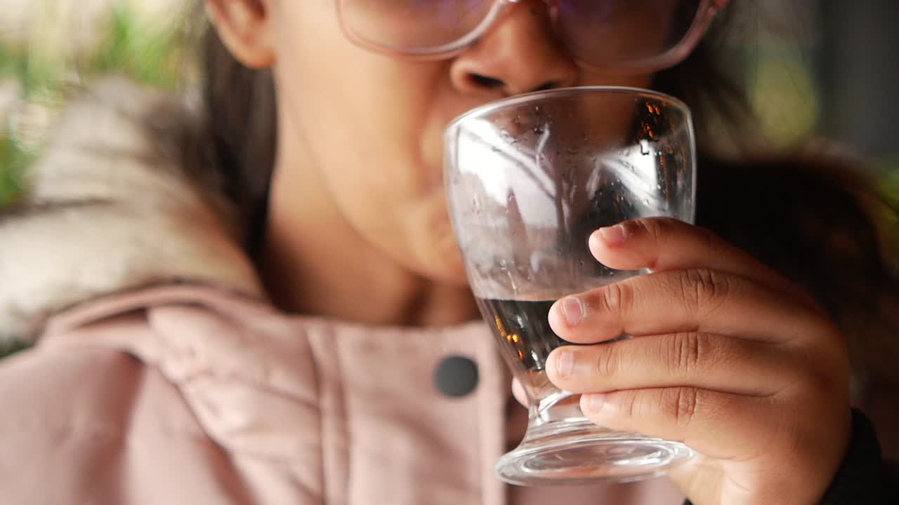 Una joven bebiendo agua.