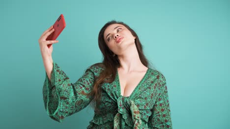 happy woman taking selfie with smartphone in blue studio