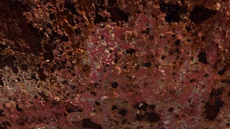 the submerged hull of the boat's structure accumulates a lot of rust and layers of paint run by the sea water after years of work fishing, close-up shot